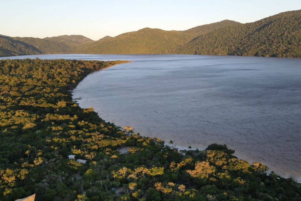 Vista panorâmica da Lagoa do Peri em Florianópolis, com água calma e vegetação nativa, destino de trilhas urbanas no Sul do Brasil